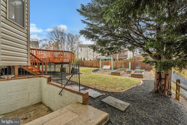 view of yard with a playground, a deck, fence private yard, a garden, and stairs