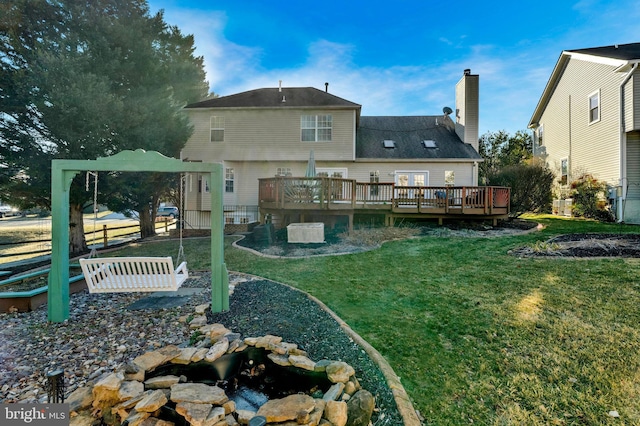 back of house with a yard, a chimney, a wooden deck, and fence