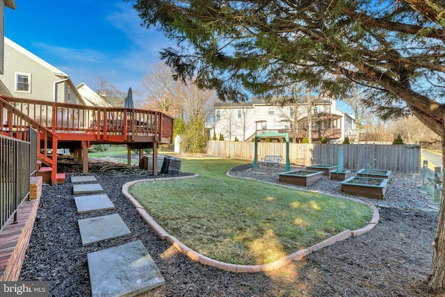 view of yard with fence, a vegetable garden, and a wooden deck