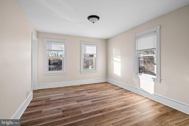 spare room featuring baseboards and wood finished floors