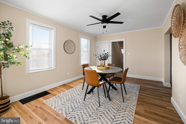 dining area featuring visible vents, baseboards, and wood finished floors