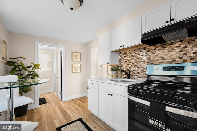 kitchen with under cabinet range hood, a sink, light wood-style floors, electric stove, and backsplash