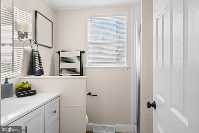 bathroom with toilet, vanity, and visible vents