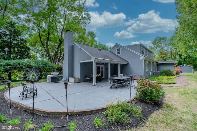 rear view of property featuring a patio area, stucco siding, a chimney, and central AC