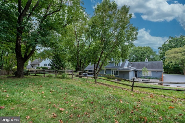 view of yard featuring an attached garage and fence