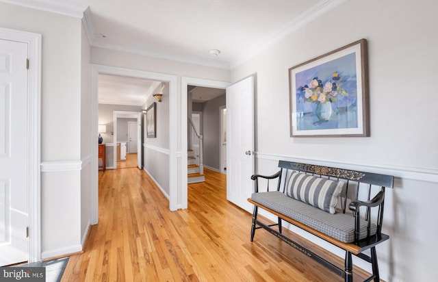 corridor featuring light wood-style flooring, crown molding, stairs, and baseboards