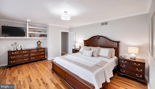 bedroom featuring visible vents, light wood-type flooring, baseboards, and ornamental molding