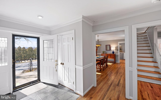 foyer entrance featuring stairway, light wood-style floors, and crown molding