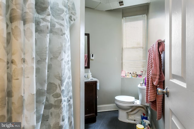 bathroom with toilet, vanity, and a shower with shower curtain