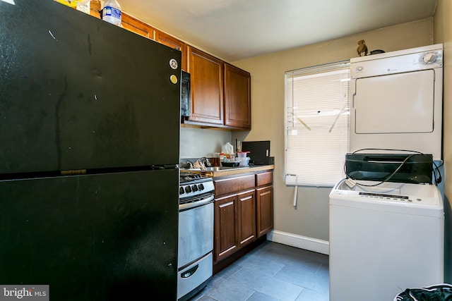 kitchen featuring stacked washer / dryer and black appliances