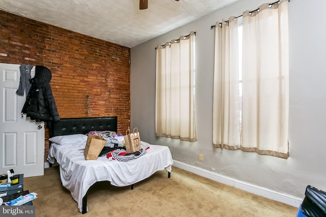 bedroom with ceiling fan, carpet, and a textured ceiling