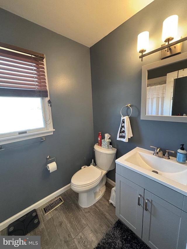 bathroom with vanity, hardwood / wood-style flooring, and toilet