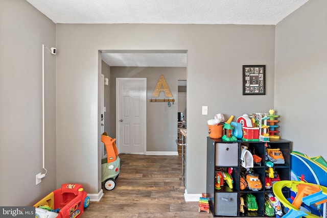 rec room with dark wood-type flooring and a textured ceiling