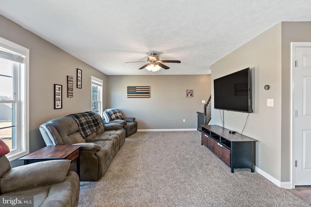 carpeted living room with a textured ceiling and ceiling fan