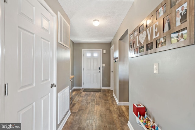 entryway featuring dark hardwood / wood-style flooring and a textured ceiling