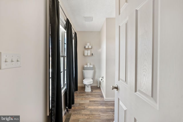 bathroom featuring a textured ceiling, toilet, and hardwood / wood-style flooring