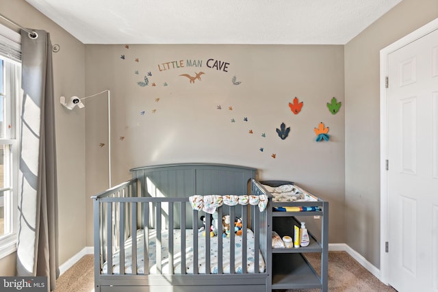 carpeted bedroom featuring a crib