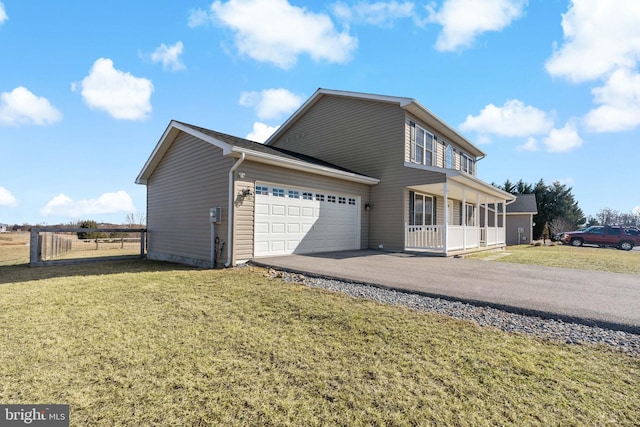 view of side of home with a garage, a lawn, and a porch