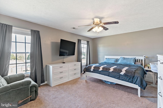 carpeted bedroom with a textured ceiling and ceiling fan