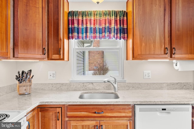 kitchen with white appliances, a sink, and light stone countertops