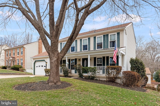 view of front of property featuring a garage, covered porch, driveway, and a front yard