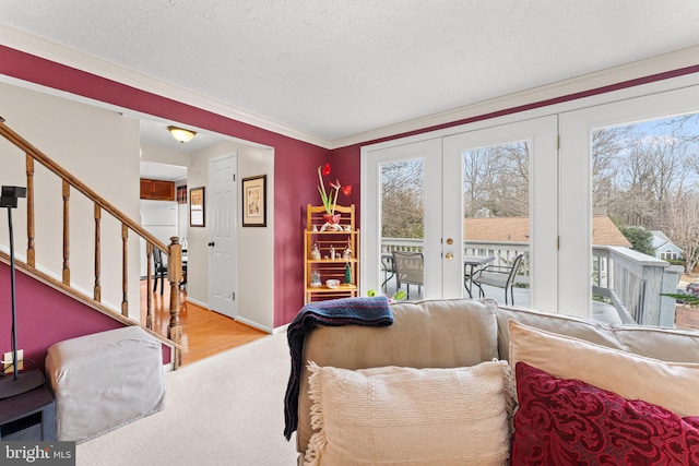 living area featuring baseboards, stairway, a textured ceiling, and french doors