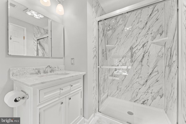 full bathroom featuring visible vents, a marble finish shower, and vanity