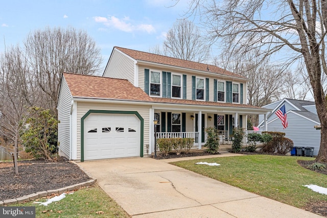 colonial home featuring roof with shingles, covered porch, concrete driveway, an attached garage, and a front yard