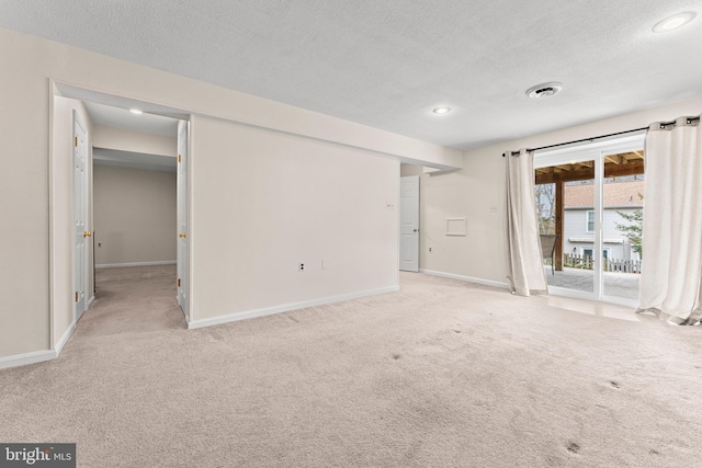 interior space featuring a textured ceiling, carpet floors, visible vents, baseboards, and access to exterior