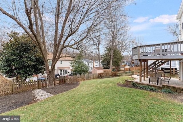 view of yard with a deck, a fenced backyard, a patio, and stairway