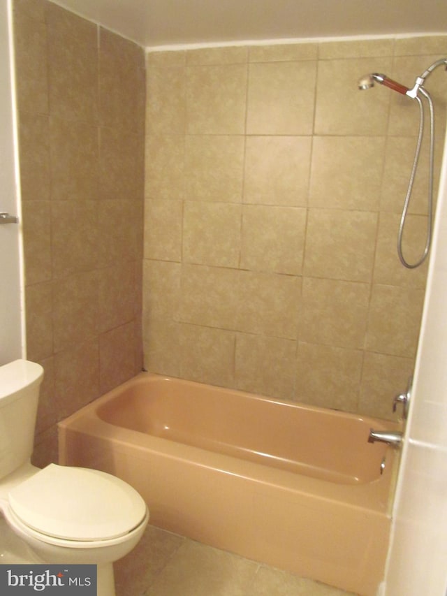 bathroom with tile patterned flooring, tiled shower / bath combo, and toilet