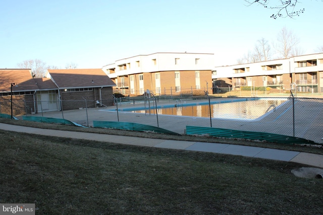 view of pool featuring a lawn