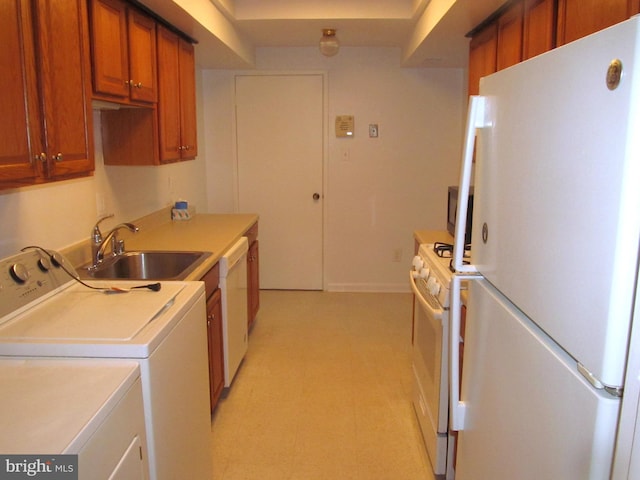 kitchen featuring sink, white appliances, and washer and clothes dryer