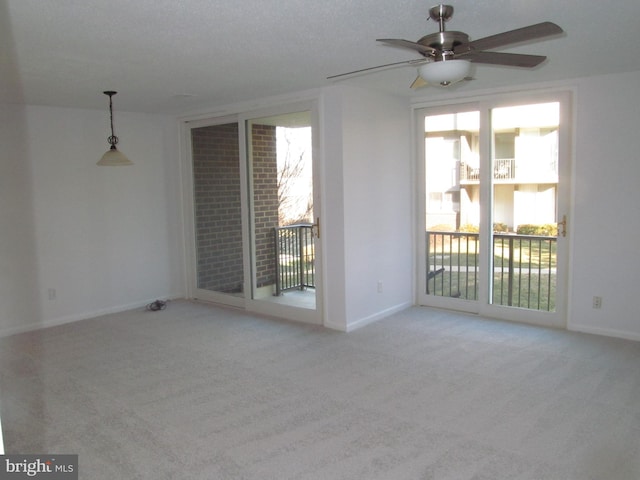 carpeted spare room featuring ceiling fan and a healthy amount of sunlight