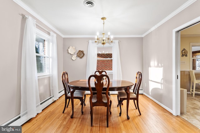 dining room featuring a chandelier, light wood-style flooring, visible vents, baseboards, and crown molding