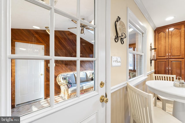 doorway featuring ornamental molding and a ceiling fan