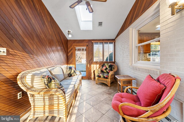 sunroom / solarium featuring vaulted ceiling with skylight, visible vents, and a ceiling fan