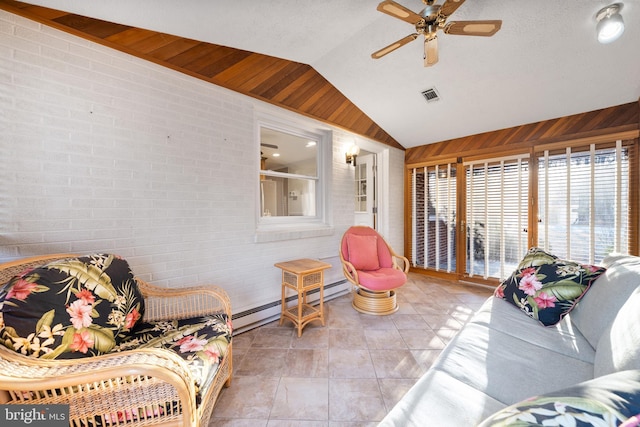 living room featuring a baseboard radiator, lofted ceiling, visible vents, ceiling fan, and brick wall