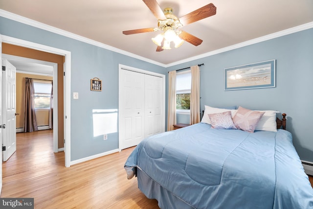 bedroom with multiple windows, crown molding, and light wood finished floors