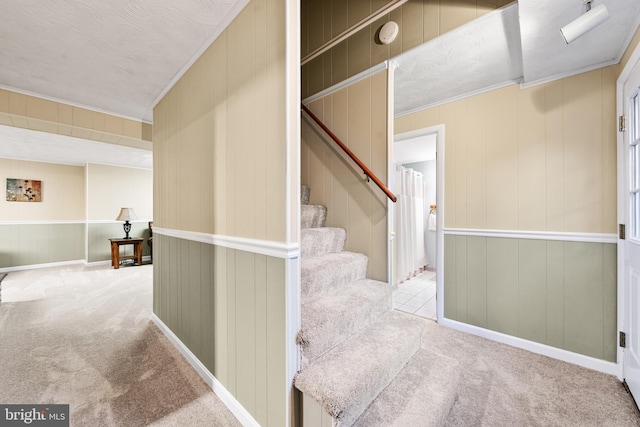 hall featuring ornamental molding, stairway, carpet flooring, and baseboards