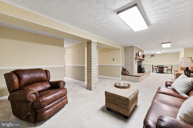 living room with carpet, a fireplace, decorative columns, and a textured ceiling