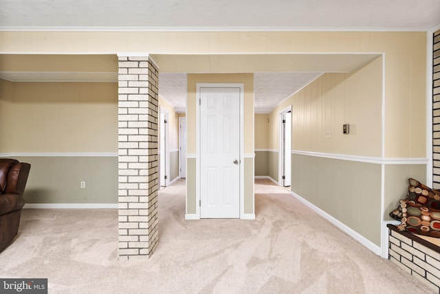 interior space featuring light carpet, ornamental molding, decorative columns, and baseboards