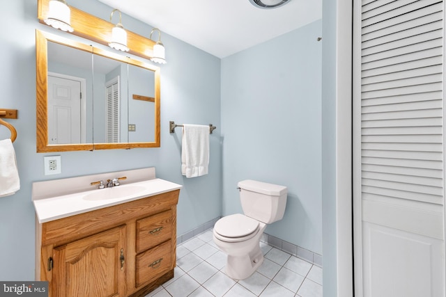 bathroom featuring toilet, tile patterned flooring, a closet, and vanity