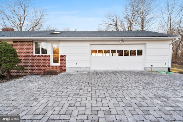 garage with decorative driveway