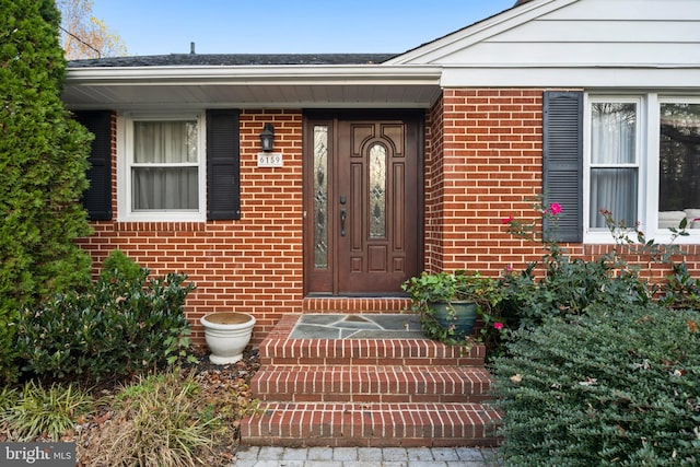 entrance to property featuring brick siding