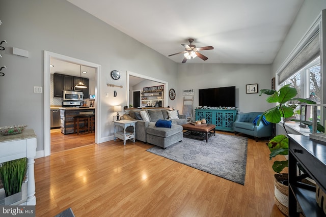 living area with lofted ceiling, wood finished floors, a ceiling fan, and baseboards