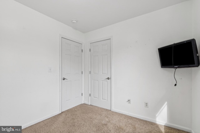 unfurnished bedroom with baseboards and carpet flooring