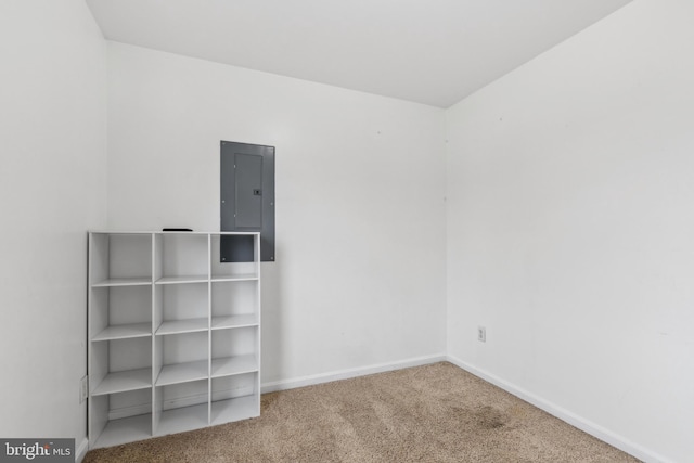 carpeted empty room with electric panel and baseboards