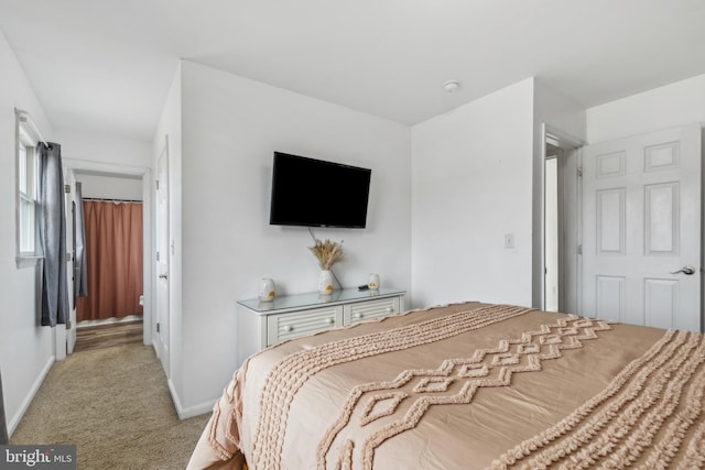 bedroom featuring baseboards and light colored carpet