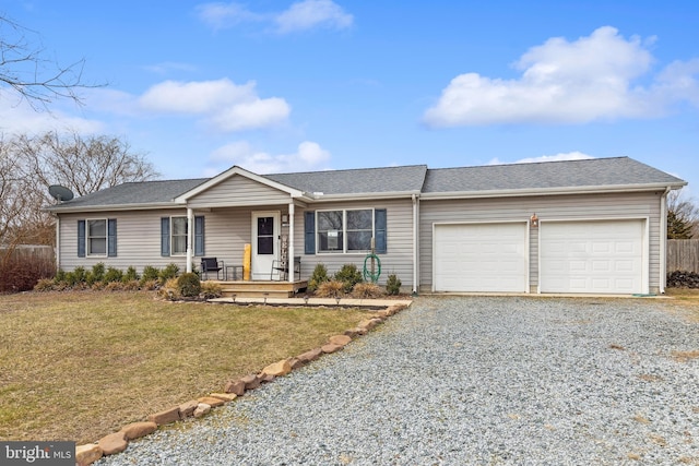 ranch-style home with gravel driveway, covered porch, a garage, and a front yard